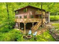 Stunning two-story house with wooden exterior, large deck, and beautiful landscaping at 13306 W 50 S, Columbus, IN 47201