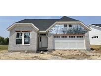New construction home showing a gray brick exterior, white garage door, and dark grey roof at 14910 Garden Mist Pl, Fishers, IN 46037