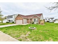 Charming single-Gathering home featuring a well-manicured lawn, brick accents, and an attached two-car garage at 1632 Blankenship Dr, Indianapolis, IN 46217