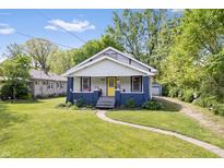 Charming bungalow-style home featuring a well-manicured lawn and inviting yellow front door at 5817 Beechwood Ave, Indianapolis, IN 46219