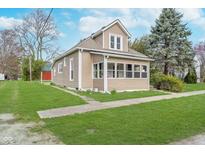 Charming tan house with a well-maintained lawn and front porch at 702 S Fanning St, Sheridan, IN 46069