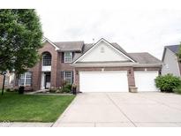 Charming two-story brick home with a three-car garage, manicured lawn, and tasteful landscaping at 8748 N Autumnview Dr, McCordsville, IN 46055