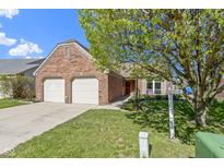 Charming brick home with a two-car garage and a well-manicured front yard and shade tree at 9526 Colony Pointe E Dr, Indianapolis, IN 46250
