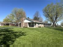 Charming single-story brick home with a brick chimney and a large, well-manicured lawn at 1020 Cottonwood Dr, Columbus, IN 47203