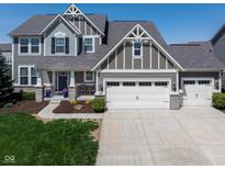 Inviting two-story home with a gray facade, manicured lawn, and a spacious driveway leading to a two-car garage at 11014 Woodpark Dr, Noblesville, IN 46060