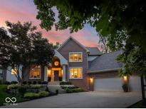 Stunning brick home featuring a landscaped front yard and attached three-car garage at 12304 Ridgeside Rd, Indianapolis, IN 46256