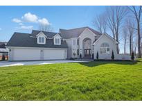 Stunning two-story home featuring a three-car garage and a well-manicured lawn at 12536 Lowery Way, Fishers, IN 46037