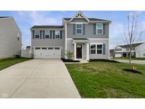 Charming two-story home with gray siding, double garage, blue shutters and a well-manicured lawn at 13813 N Hawkers Hill Dr, Camby, IN 46113