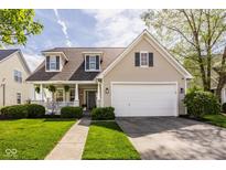 Charming two-story home featuring a covered porch, manicured lawn, and a two-car garage at 15037 Rutherford Dr, Westfield, IN 46074