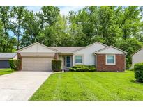 Charming single-story home with a well-manicured lawn and attached two-car garage at 1697 Stacy Lynn Dr, Indianapolis, IN 46231