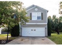 Traditional home with a two-car garage, basketball hoop, neutral siding, and simple landscaping at 4545 E Connaught East Dr, Plainfield, IN 46168