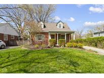 Charming red brick home with lush landscaping and a well-manicured lawn at 4640 Boulevard Pl, Indianapolis, IN 46208