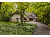 Charming brick home with mature trees, landscaping, and a circular driveway at 7249 Tuliptree Trl, Indianapolis, IN 46256