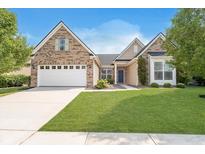 Charming brick home featuring a well-manicured lawn, two-car garage, and inviting curb appeal at 1315 Hazy Falls Blvd, Westfield, IN 46074