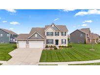 Beautiful two-story home with a manicured lawn, a three-car garage, and a classic brick and siding facade at 1334 Winfield Way, Greenwood, IN 46143