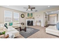 Bright living room featuring a fireplace, a ceiling fan, and ample natural light at 1334 Winfield Way, Greenwood, IN 46143