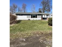 A single-story home featuring light grey siding, large front window, and a well-maintained lawn in a residential neighborhood at 1618 E 24Th St, Muncie, IN 47302