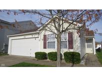 Charming home featuring an attached garage, neat shrubbery, and classic neutral siding at 1833 Southernwood Ln, Indianapolis, IN 46231
