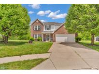 Traditional two-story home featuring a brick facade, attached two car garage, and well-maintained landscaping at 2303 Cole Wood Ct, Indianapolis, IN 46239