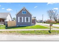 Charming gray home features a well-manicured lawn and classic white-trimmed windows and shutters at 401 N Swope St, Greenfield, IN 46140