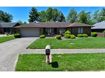 Charming brick ranch-style home with lush landscaping and a well-maintained lawn at 6318 Dahlia Dr, Indianapolis, IN 46217