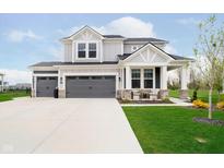 Beautiful two-story home with a three-car garage, gray siding, and manicured landscaping at 7158 Sugar Maple Ln, Brownsburg, IN 46112