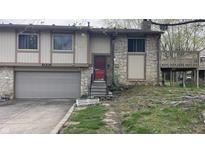 Two story home featuring a stone facade, attached garage, and elevated deck at 8006 Sunfield Ct, Indianapolis, IN 46214