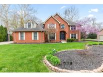 Charming brick home with a manicured lawn, blossoming tree, and welcoming curb appeal at 945 Baywood Ct, Columbus, IN 47201