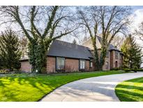 Beautiful brick home featuring mature trees, a paved driveway and lush green lawn at 10605 Winterwood, Carmel, IN 46032