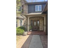 Inviting front entrance featuring a beautiful wood door with stone accents and a well-manicured landscape at 11347 Whitewater Way, Fishers, IN 46037