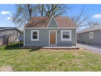 Charming bungalow featuring a light green exterior, a brown roof, and a small, quaint front yard at 1409 S Kiel Ave, Indianapolis, IN 46241