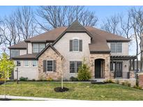 Beautiful two-story home showcasing a mix of brick and stone exterior with a well-manicured lawn at 14872 Autumn View Way, Fishers, IN 46037