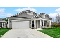 Charming home with a gray exterior, a white garage door, and a well-manicured lawn at 16870 Imperial Ct, Fishers, IN 46040