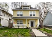 Charming two-story home with a welcoming front porch, black door, and beautiful lawn at 3133 Ruckle St, Indianapolis, IN 46205