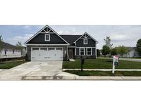 Charming two-story home with gray siding, stone accents, a well-manicured lawn, and an attached two-car garage at 5125 Gerhing Dr, Indianapolis, IN 46239