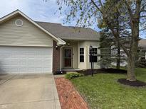 Charming home featuring a brick entryway, manicured lawn, and attached two-car garage at 6318 Amarillo Way, Indianapolis, IN 46237