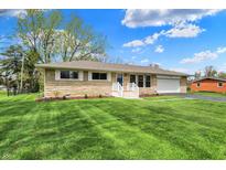 Charming single-story home with stone facade, attached garage, and beautifully maintained lawn at 6826 Hague Rd, Indianapolis, IN 46256