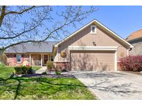 Charming home featuring a well-maintained lawn, brick accents, and a two-car garage at 7634 Pennycroft Dr, Indianapolis, IN 46236