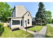 Charming two-story home with a well-maintained lawn and inviting curb appeal on a sunny day at 106 S Wayburn St, Indianapolis, IN 46229