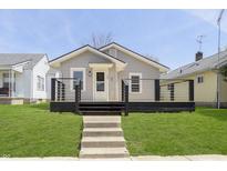Charming bungalow featuring a welcoming porch, light gray siding and manicured front lawn at 109 S 10Th S Ave, Beech Grove, IN 46107