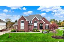Beautiful two-story red brick home features lush landscaping and a well-manicured lawn at 13682 Frenchmans Creek, Carmel, IN 46032