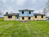 Charming two-story home with a well-maintained lawn and light blue siding, offering a welcoming curb appeal at 1387 W Furry Rd, Fountaintown, IN 46130
