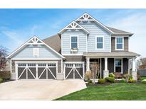 Charming two-story home with blue siding, a three-car garage, and beautifully landscaped front yard at 18488 Jaden Dr, Westfield, IN 46062