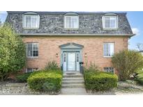 Charming brick facade of a two-story condominium with a well-manicured front entrance and dormer windows at 6017 E 52Nd Pl, Indianapolis, IN 46226