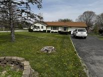Charming single-story home featuring a well-manicured front yard and paved driveway at 712 E Mckenzie Rd, Greenfield, IN 46140