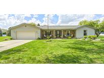 Charming ranch home featuring a stone facade, a well-manicured lawn, and an attached two-car garage at 7170 Janean Dr, Brownsburg, IN 46112