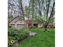 Charming brick home featuring a well-manicured lawn, mature trees, and an attached two-car garage at 7594 W Williamswood Dr, New Palestine, IN 46163