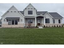 Beautiful two-story home with stone accents, a covered porch, and a lush green lawn at 8083 Easton Ln, Zionsville, IN 46077