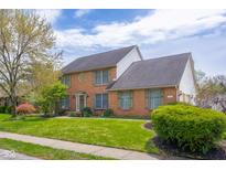 Beautiful two-story brick home with lush green lawn and landscaped garden, featuring a classic and inviting facade at 933 Hummingbird Ln, Columbus, IN 47203