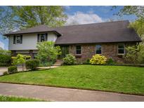 Charming two-story home with a well-maintained lawn, attached two-car garage, and mature landscaping at 961 Parkside Dr, Columbus, IN 47203